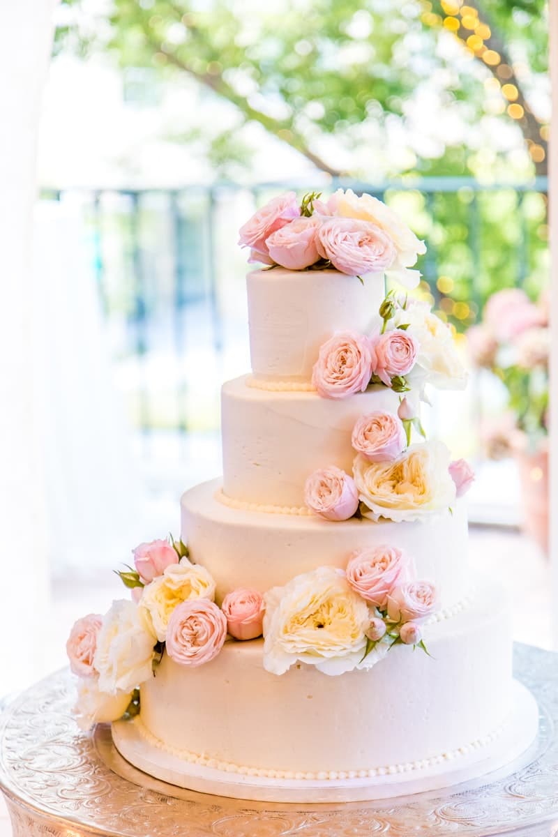 Four-tier blush pink cake with cascading roses